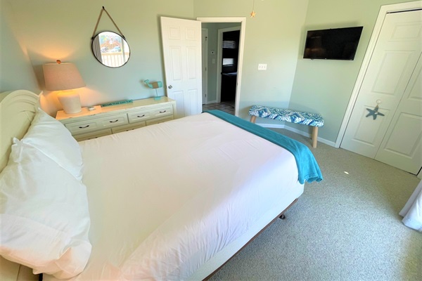 Drift off peacefully in this serene coastal bedroom with soft linens, calming décor, and your own smart TV for nighttime relaxation.