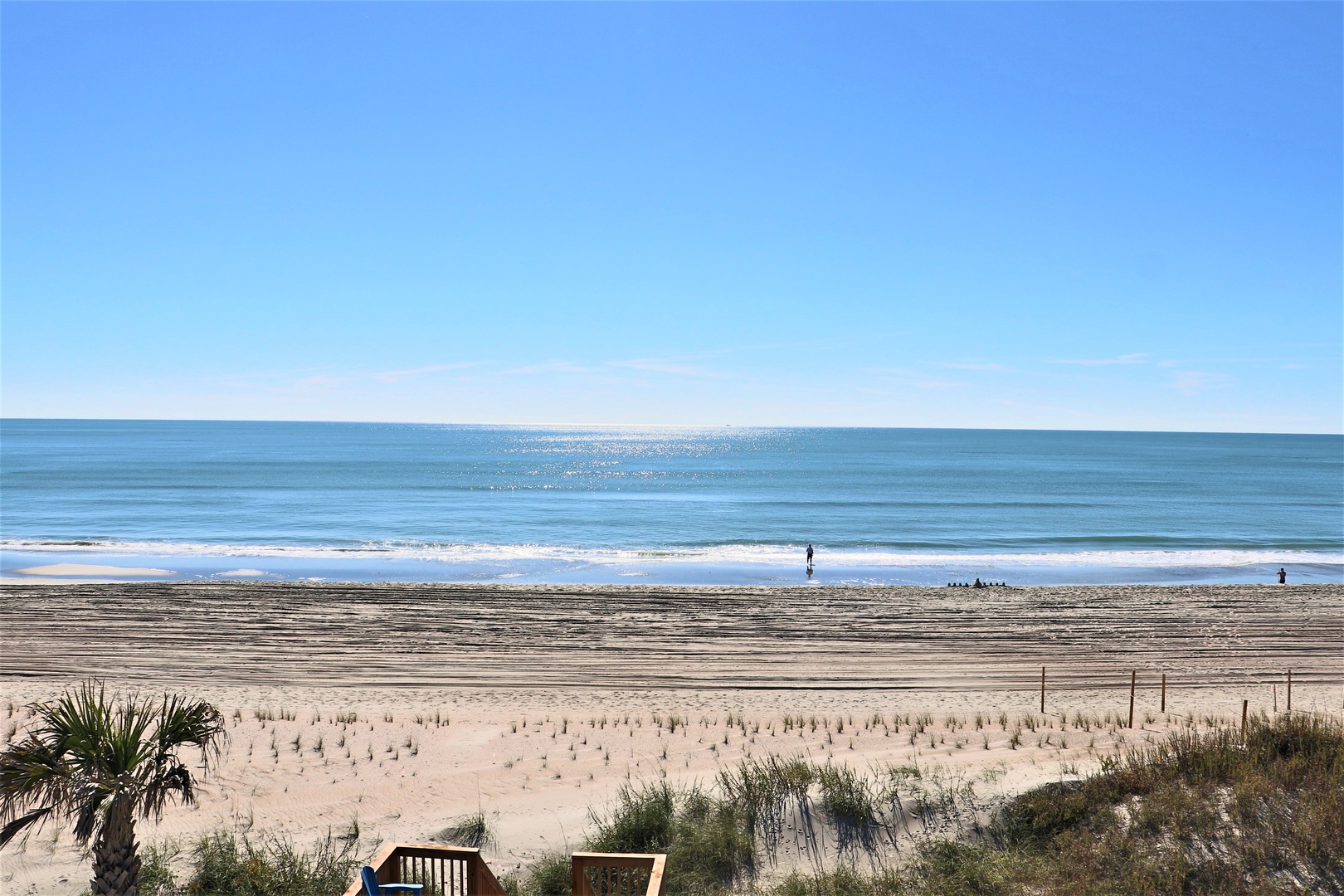 Pristine beachfront stretches endlessly before the property, offering direct access to soft sand and sparkling ocean waves.