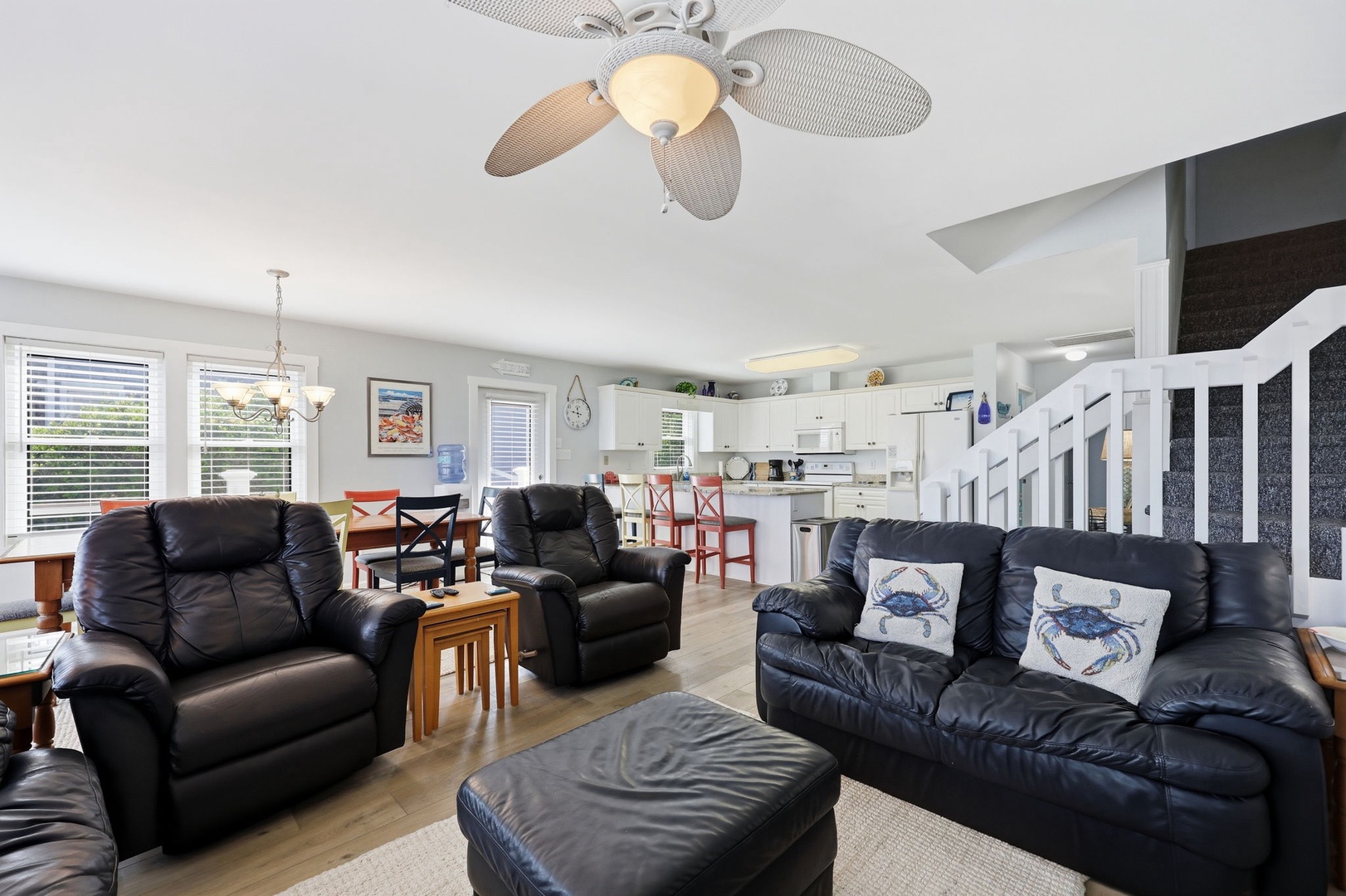 Sink into soft leather seating in your spacious open-concept living area, where coastal charm meets comfort. The ceiling fan keeps things breezy while you relax near the fully-equipped kitchen.