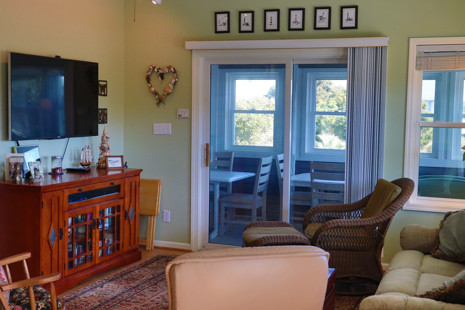 Unwind in your cozy living room with comfortable seating, flatscreen TV, and peaceful views of lush greenery through French doors.