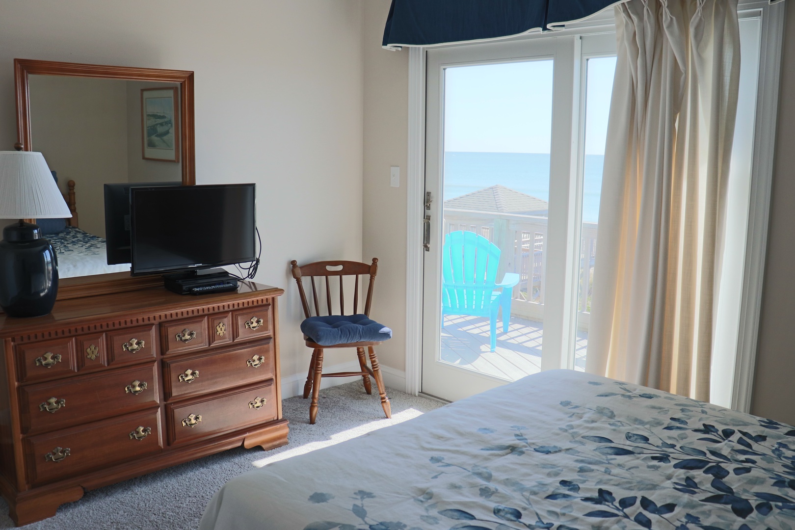 Wake up to stunning ocean views from your cozy bedroom, where natural light pours through sliding doors to your private balcony.