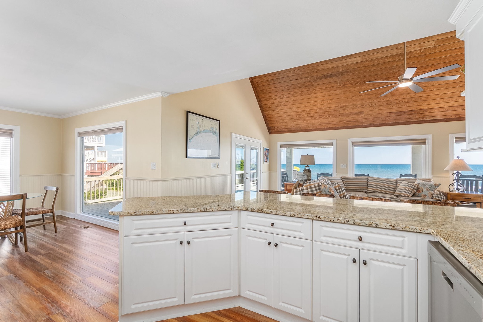 Your bright kitchen flows seamlessly into the living area, where stunning ocean views through panoramic windows create the perfect backdrop for cooking and relaxing.