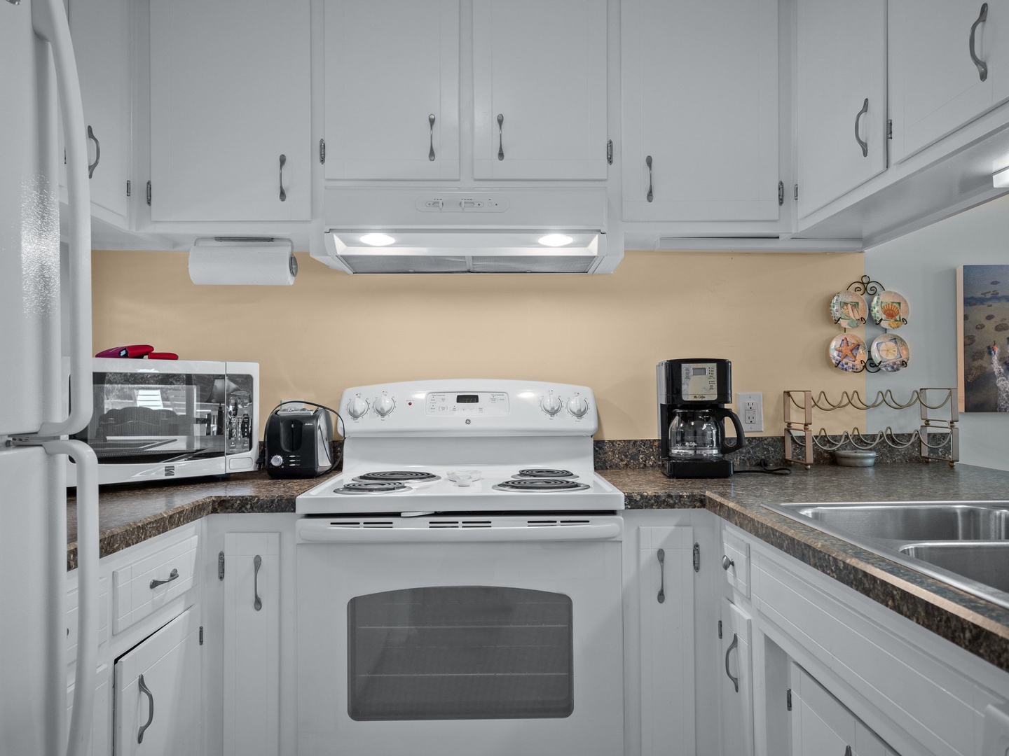 Your fully equipped kitchen awaits with granite counters, white cabinets, and modern appliances for preparing delicious home-cooked meals.