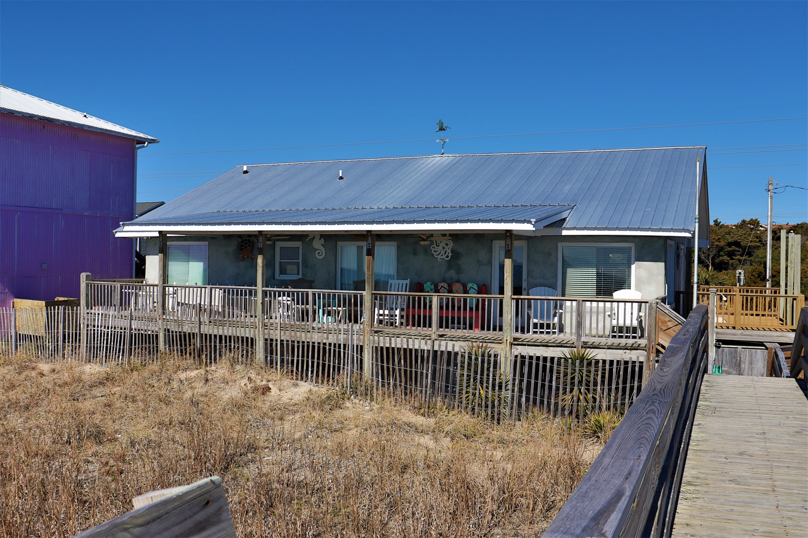 Charming beachfront cottage with wraparound deck and direct boardwalk access to the shore.