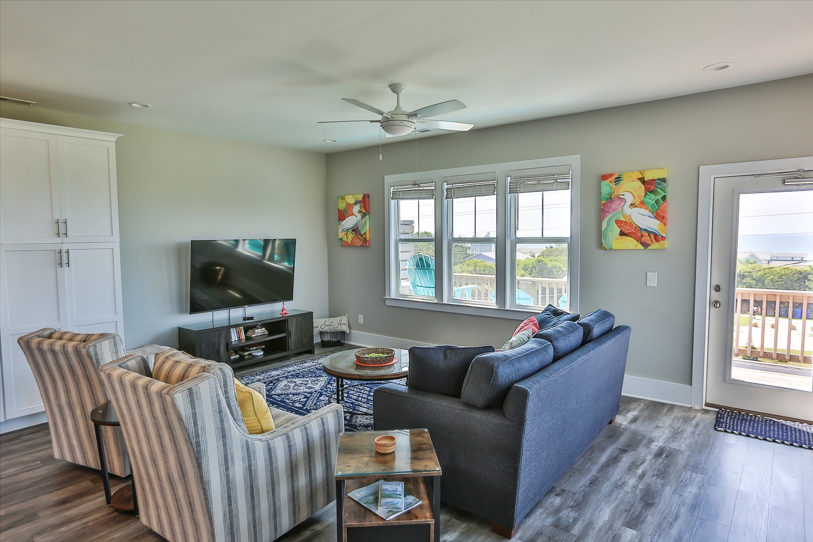 Relax in your bright living space with colorful artwork, comfortable seating, and stunning water views through oversized windows.