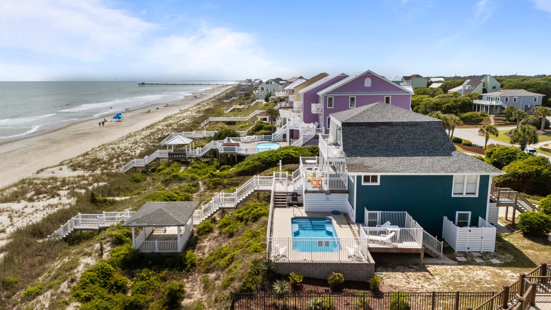Stunning beachfront retreat featuring colorful coastal homes, private pools, and direct beach access with pristine sandy shores stretching endlessly.