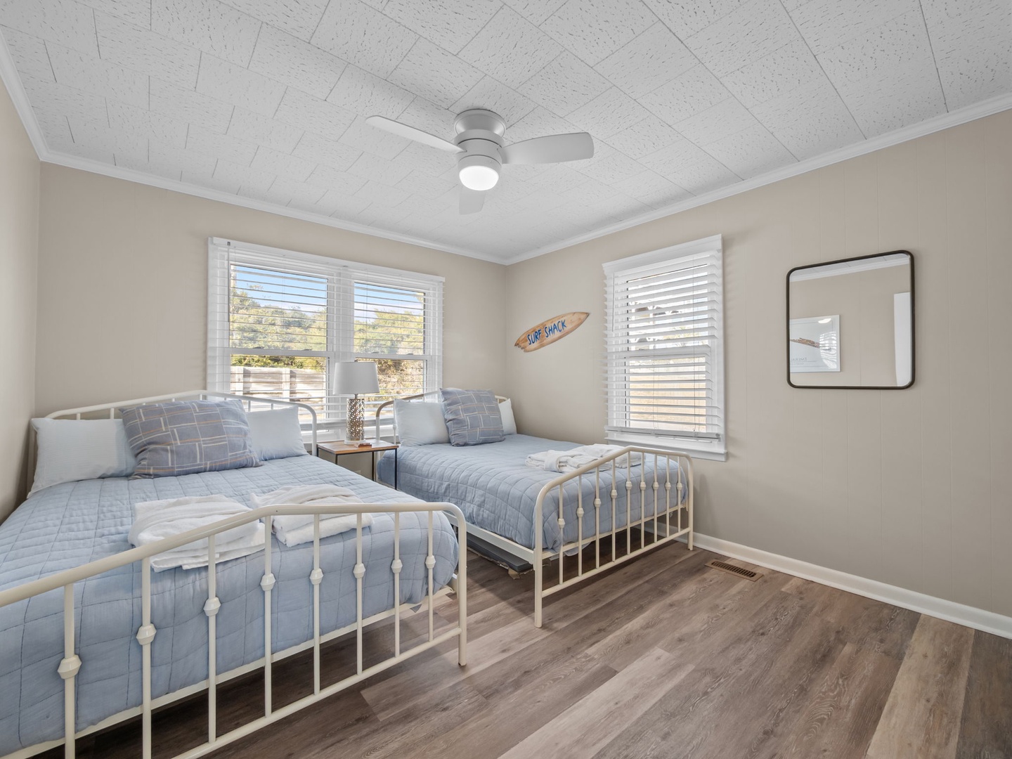 Rest peacefully in these twin beds with soft blue linens and warm coastal touches, perfect for siblings or friends sharing.