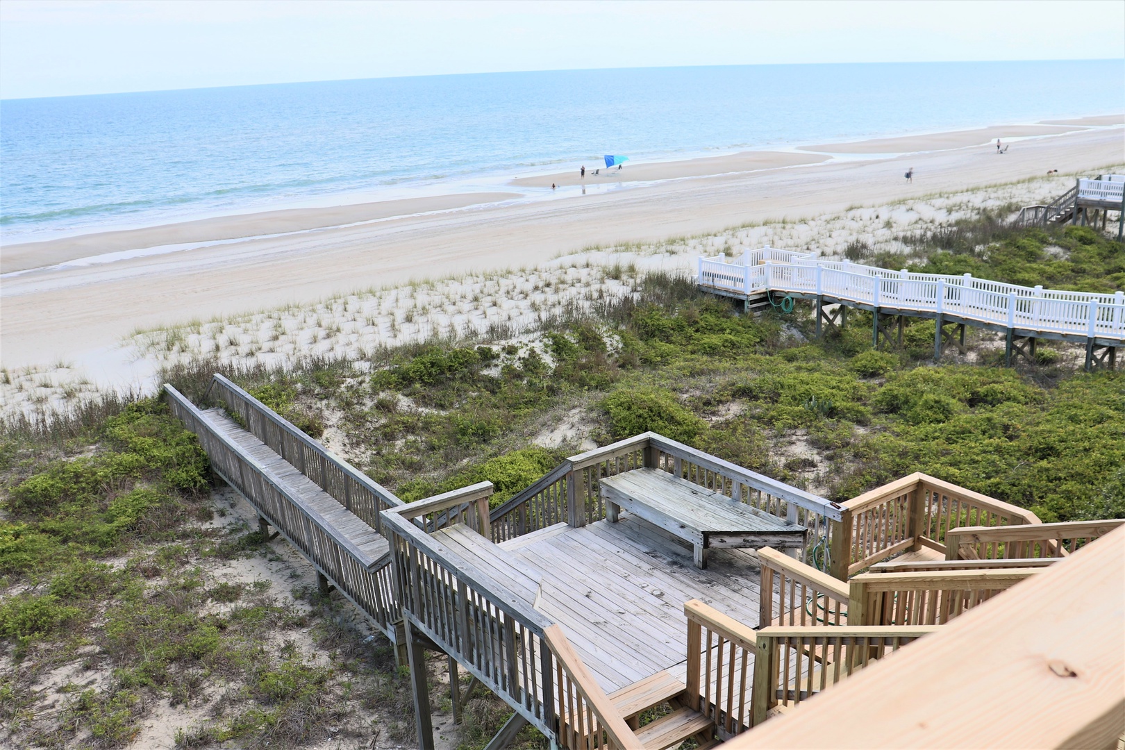 Pristine beachfront with elevated walkways leading to endless sandy shores and rolling waves.