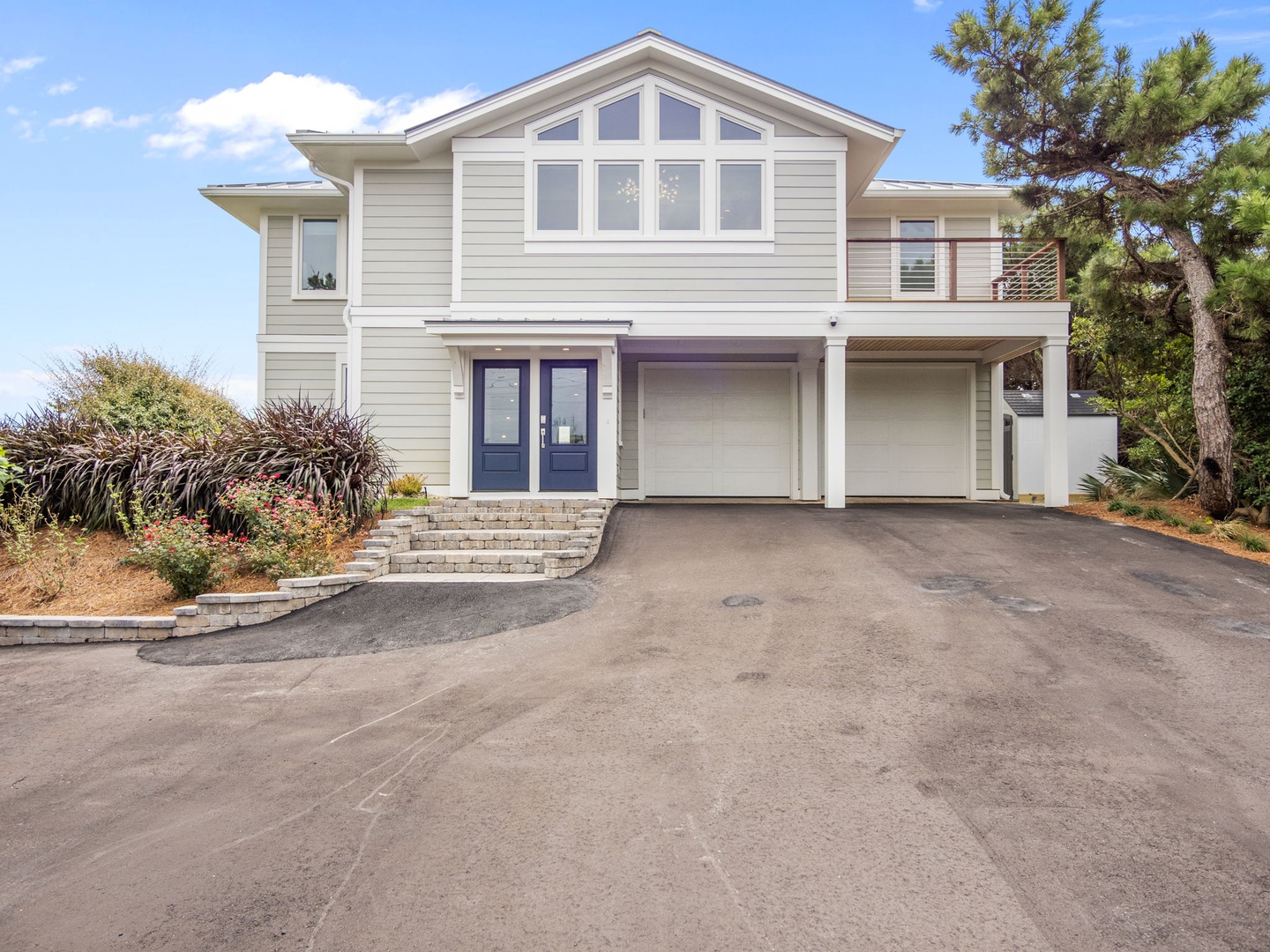 Modern beachside property featuring clean lines, spacious garage, and tropical landscaping in a peaceful setting.