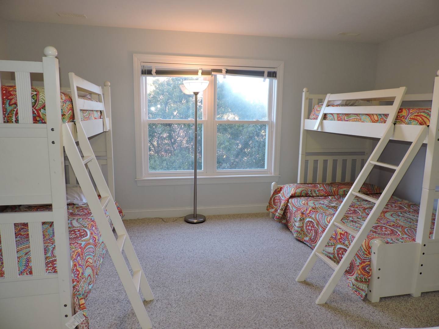 Your kids will love this bright bunk room with colorful bedding and natural light streaming through large windows.