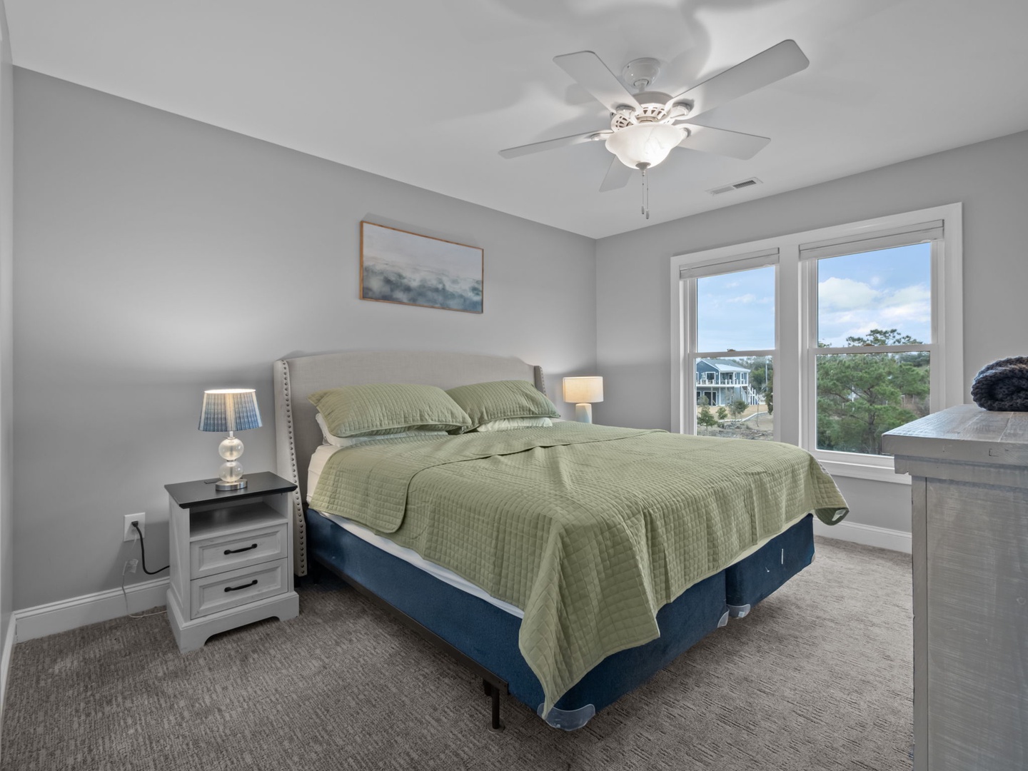 Rest peacefully in this serene bedroom with plush bedding, gentle ceiling fan, and tranquil views of the surrounding neighborhood.
