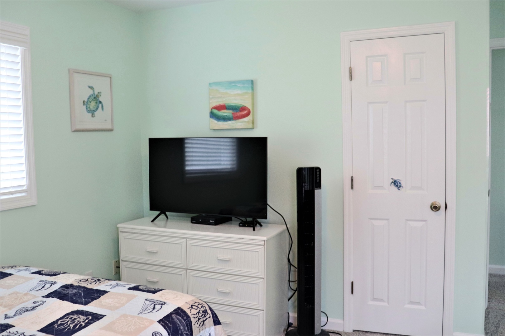 Your bright bedroom features coastal artwork and modern amenities, creating the perfect retreat for unwinding after beach adventures.