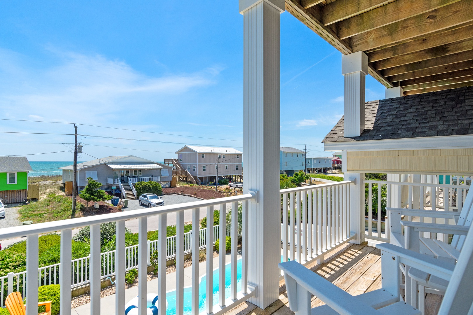 Sip your morning coffee on this charming covered balcony while enjoying ocean glimpses and coastal neighborhood views.