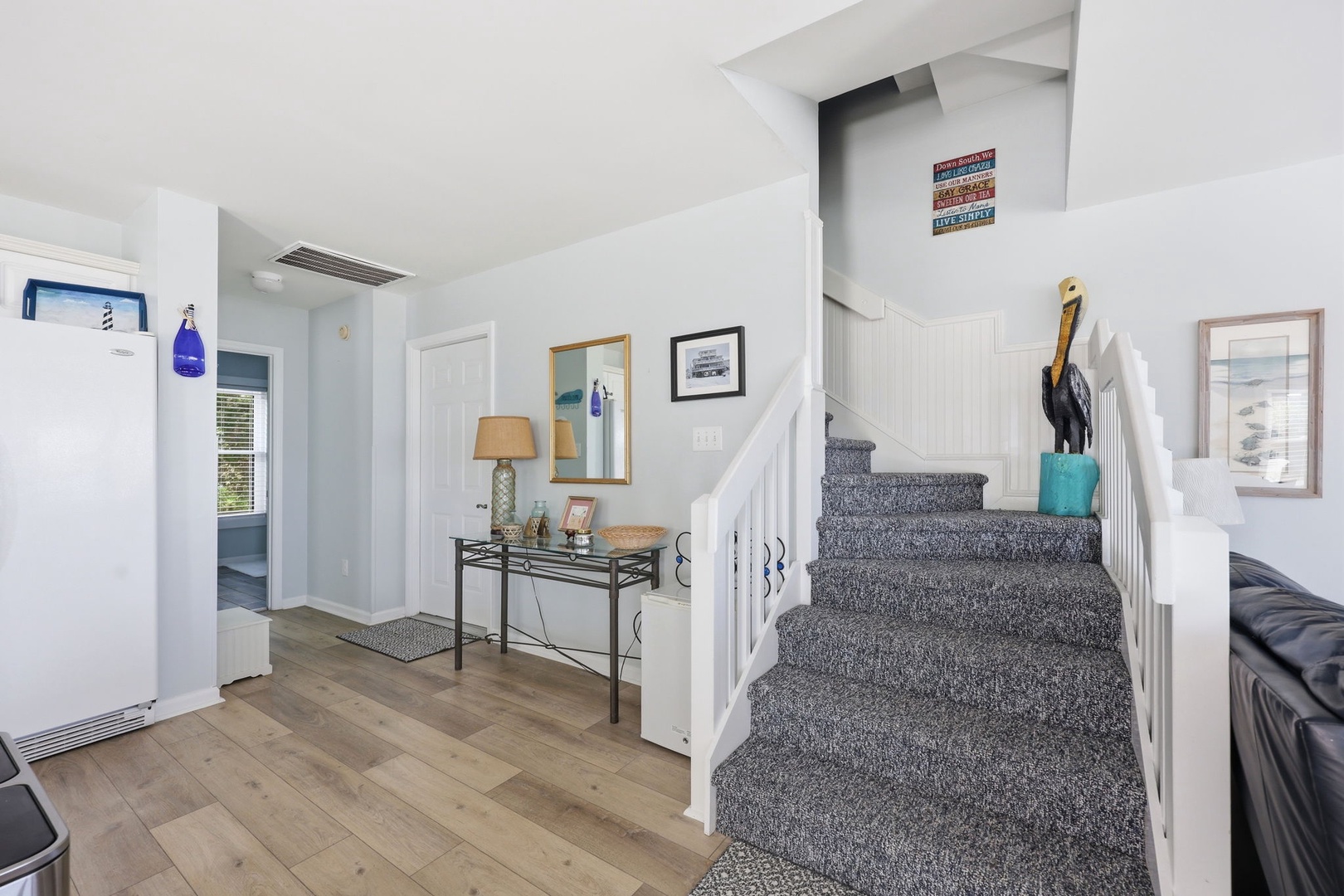 Light-filled entry with coastal touches welcomes you home—notice the charming nautical accents and console table perfect for setting down your beach finds.