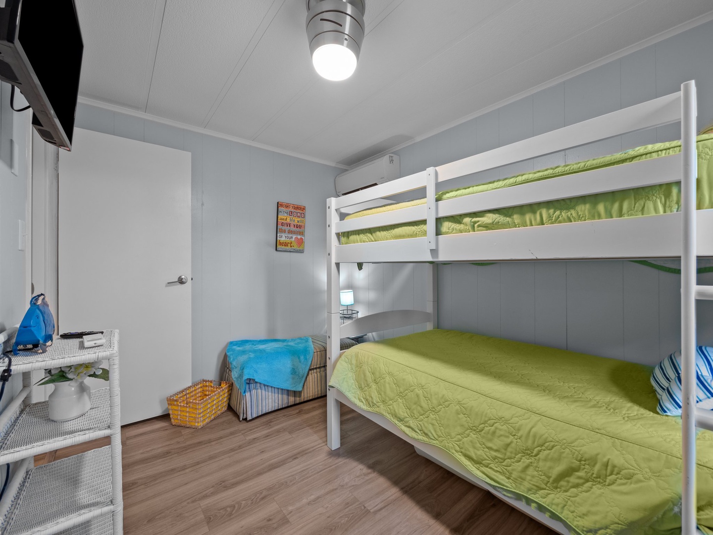 Your bright bedroom features comfortable bunk beds with vibrant green linens, perfect for families or friends sharing adventures together.
