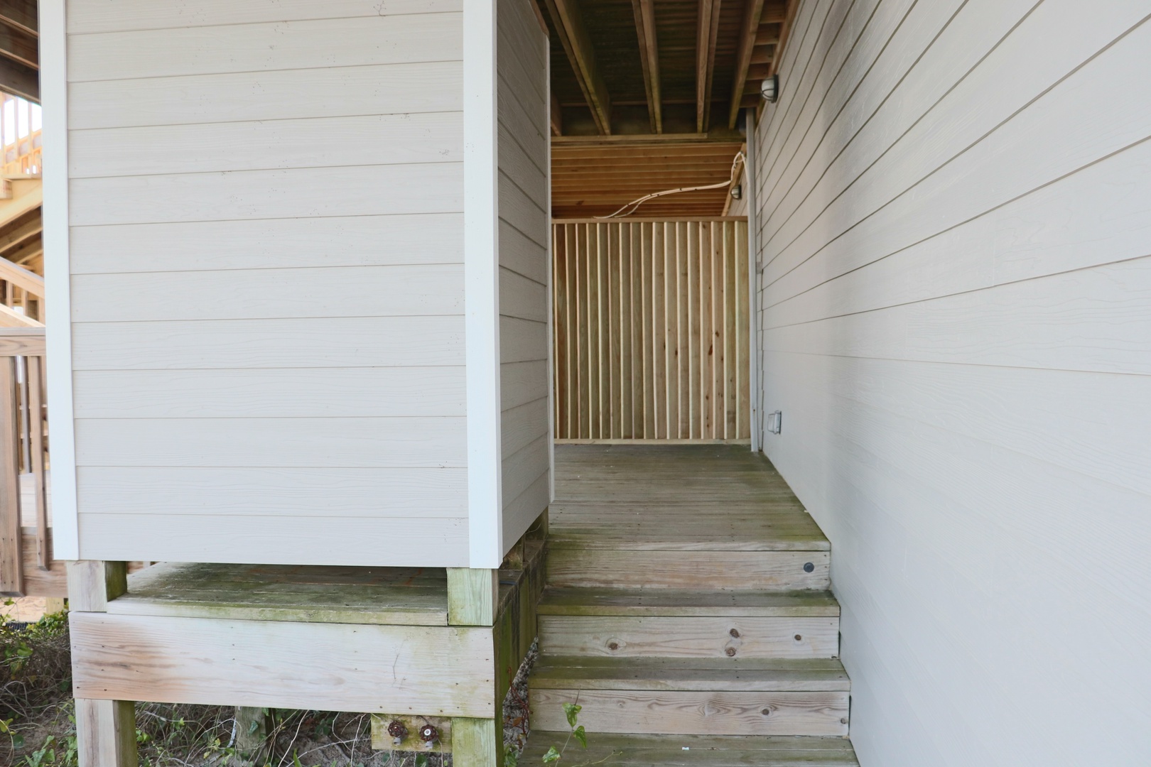 Step up to your private entrance with charming wooden stairs leading to your covered porch, complete with rustic railings and cozy cottage details.