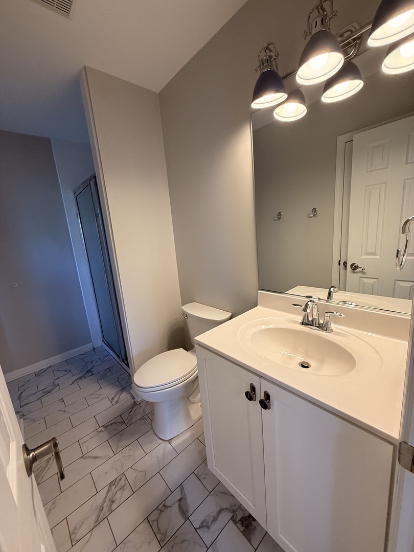 Step into your spotless private bathroom with crisp white finishes, sleek marble-look tile, and modern fixtures—perfect for refreshing morning routines and relaxing evenings.