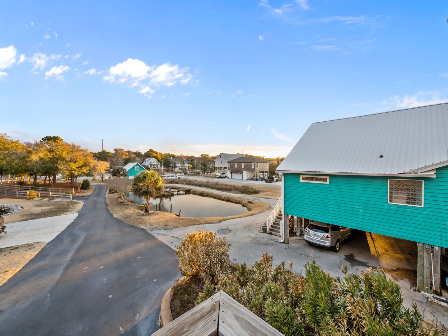 Coastal community with colorful beach houses, waterways, and peaceful residential streets under bright blue skies.