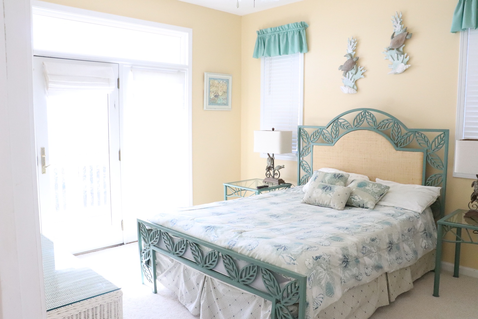 Rest peacefully in your coastal-themed bedroom with elegant sea-green furnishings and soft natural light streaming through French doors.