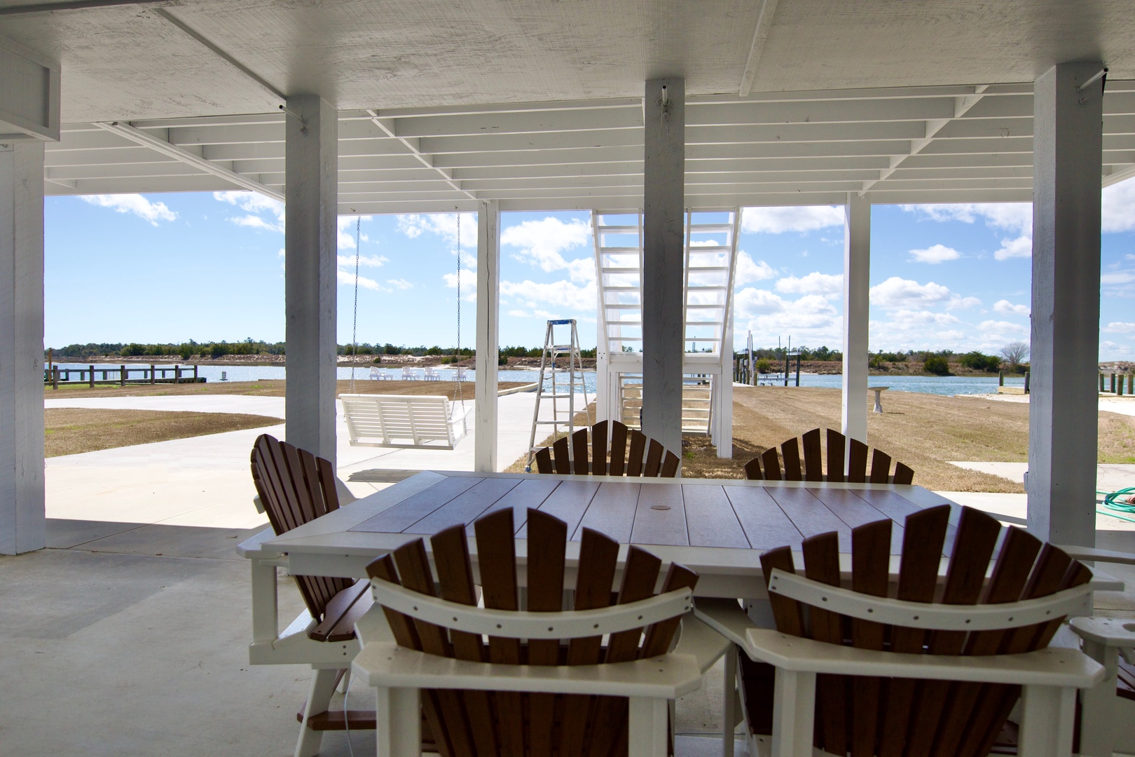Gather around your waterfront dining table where ocean breezes flow through this covered patio, perfect for meals with stunning marina views.