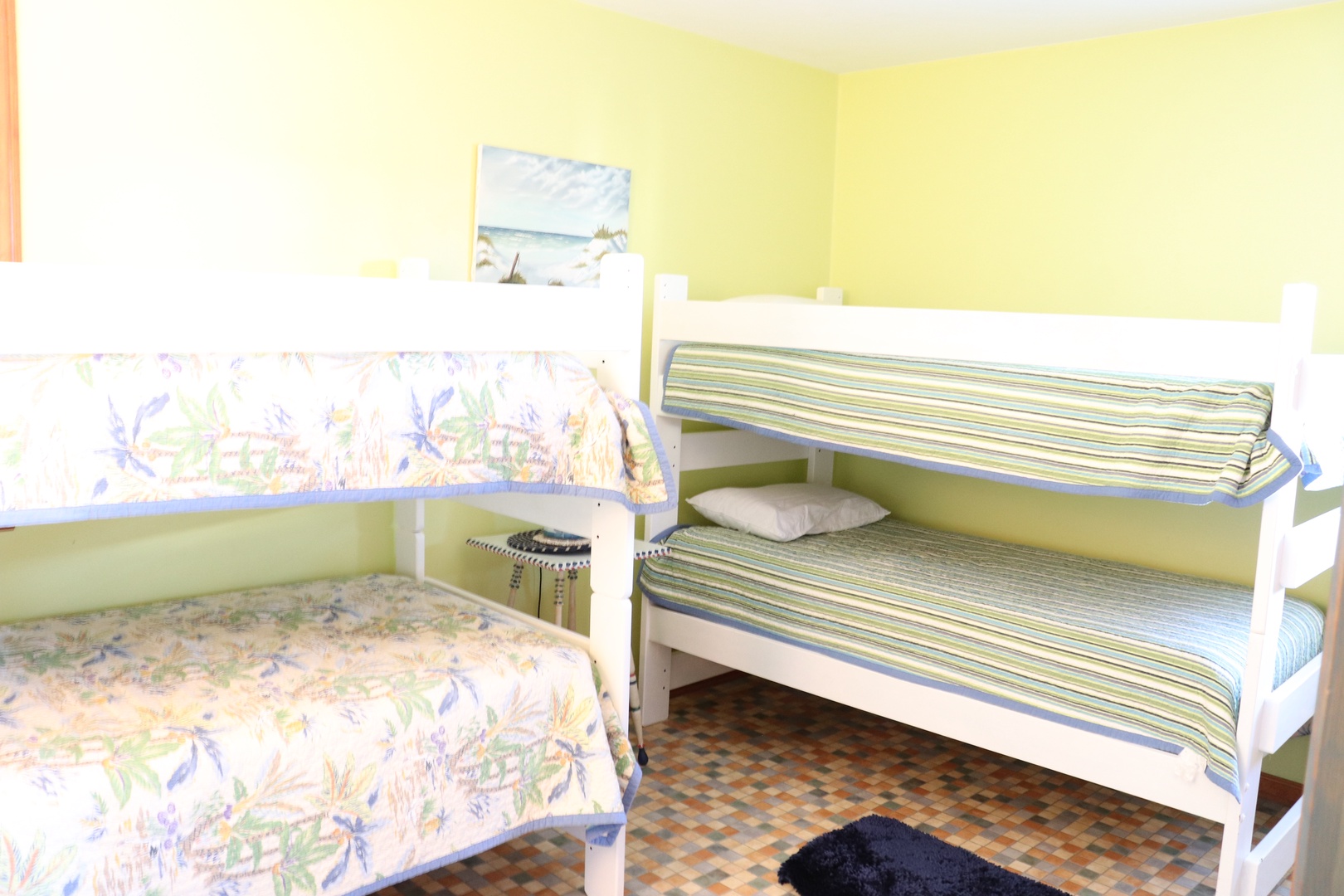 Your family-friendly bedroom features cheerful yellow walls and comfortable sleeping for four with twin beds and a cozy bunk bed setup.