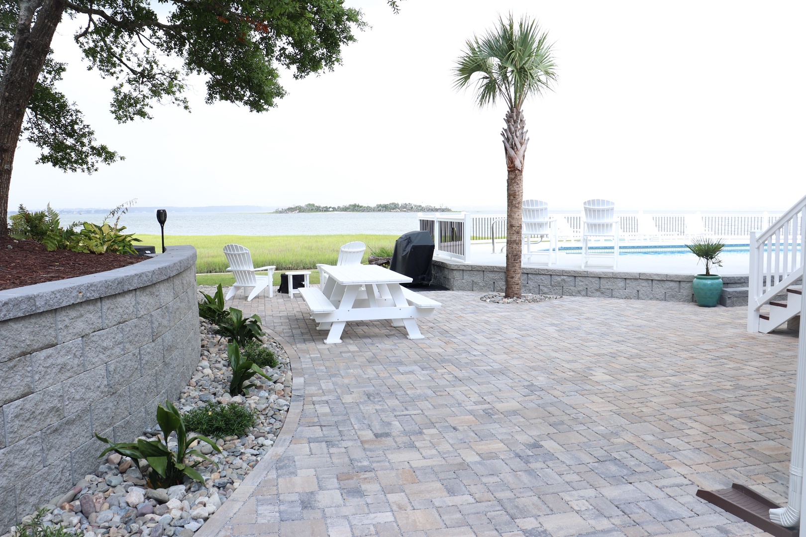 Relax on your private paver patio with stunning water views, complete with pool, BBQ, and comfortable seating for unforgettable evenings.