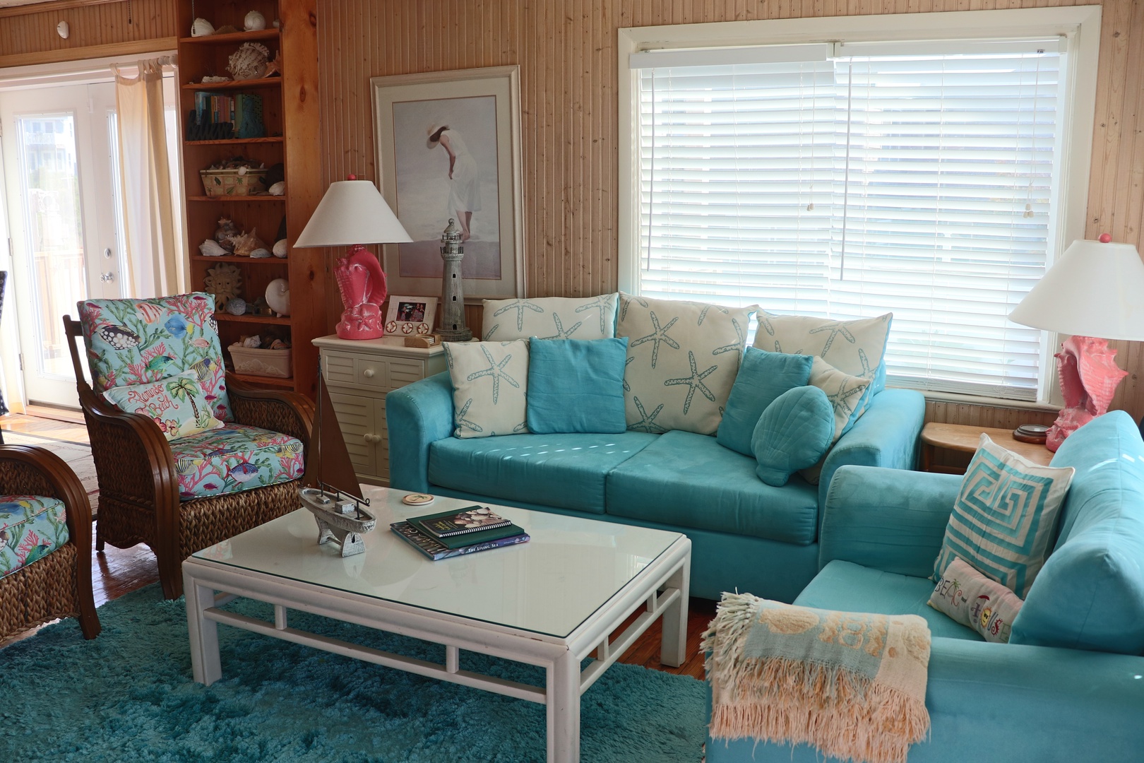 Sink into this coastal-inspired living room where turquoise sofas and starfish pillows create your perfect beach retreat sanctuary.