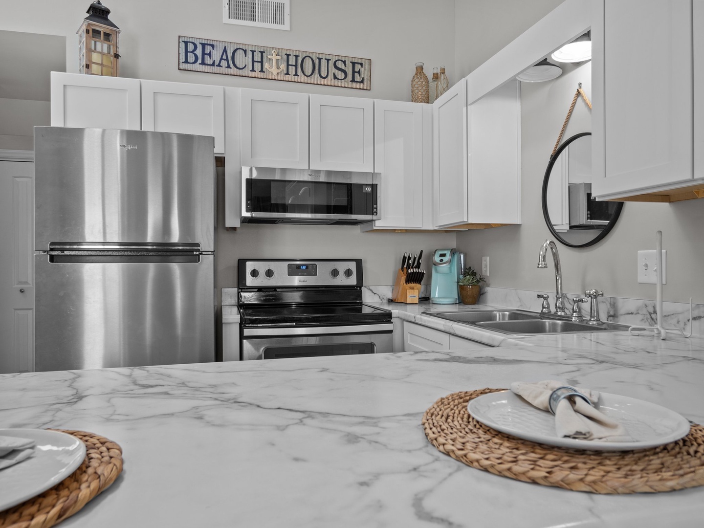 Your fully equipped kitchen features stainless steel appliances and marble countertops, perfect for preparing meals with coastal charm.