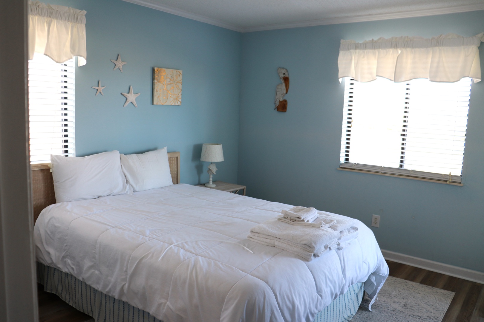 Drift into peaceful dreams in this coastal-themed bedroom with crisp linens and fresh towels awaiting your arrival.