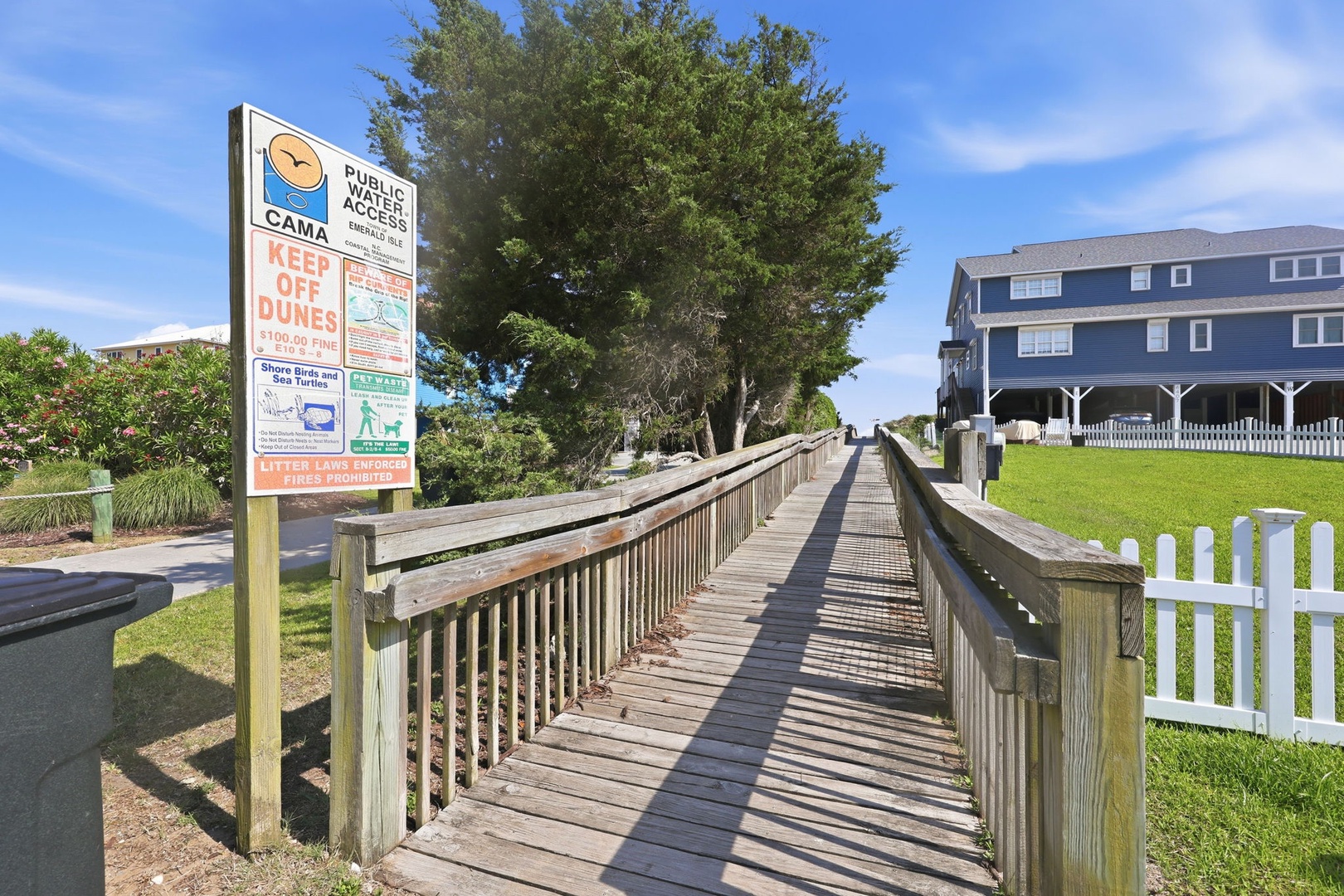 A wooden boardwalk leads through a coastal community with nearby public beach access, offering convenient paths to the shoreline and surrounding neighborhood.