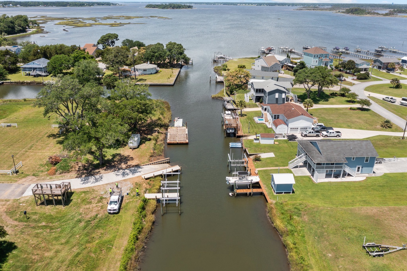 Aerial view of waterfront community with private docks, boat access, and canal-front homes surrounded by scenic marshlands.