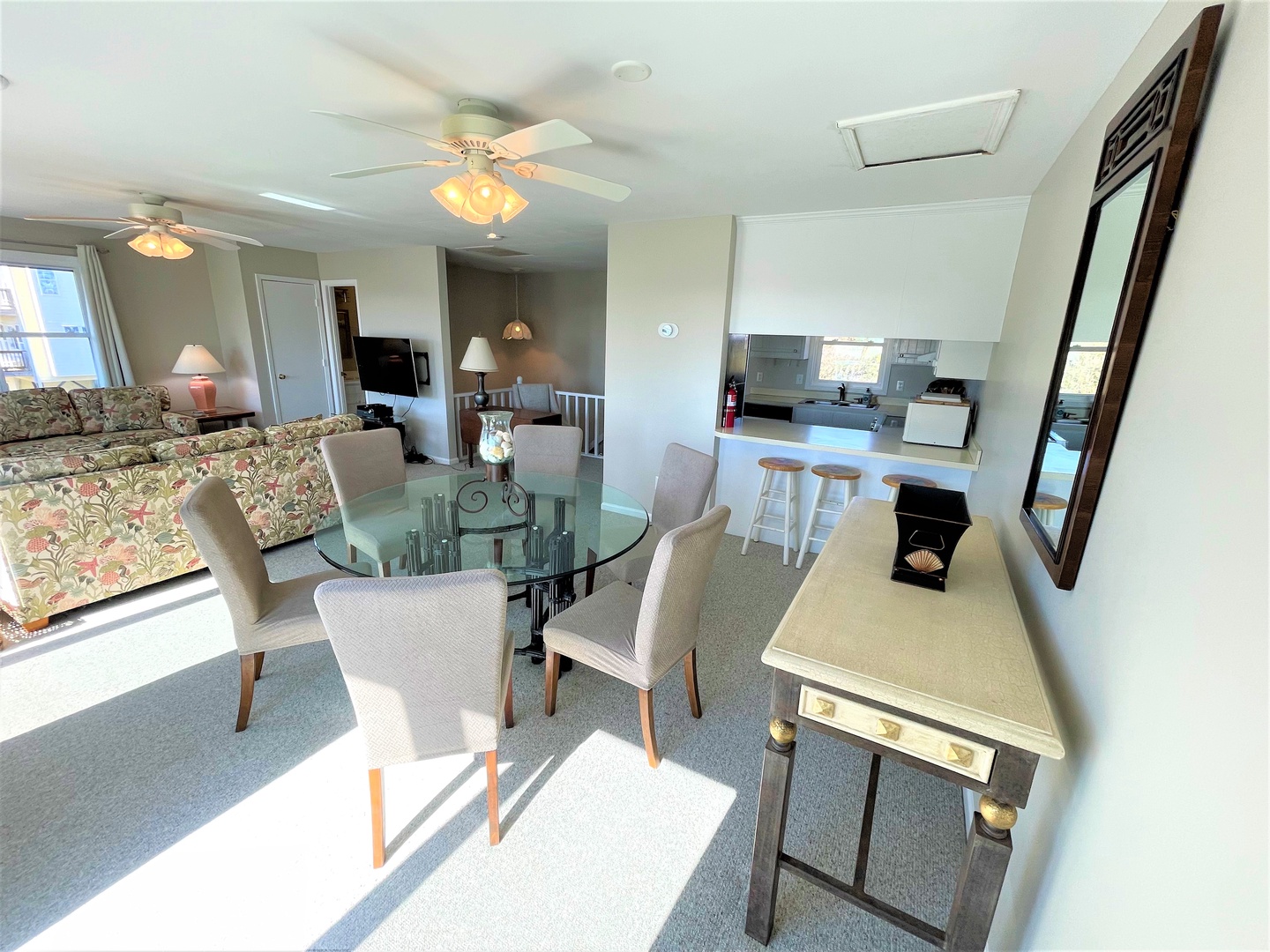 Your bright open-concept space seamlessly blends comfort and style, featuring a glass dining table, cozy seating, and fully equipped kitchen.