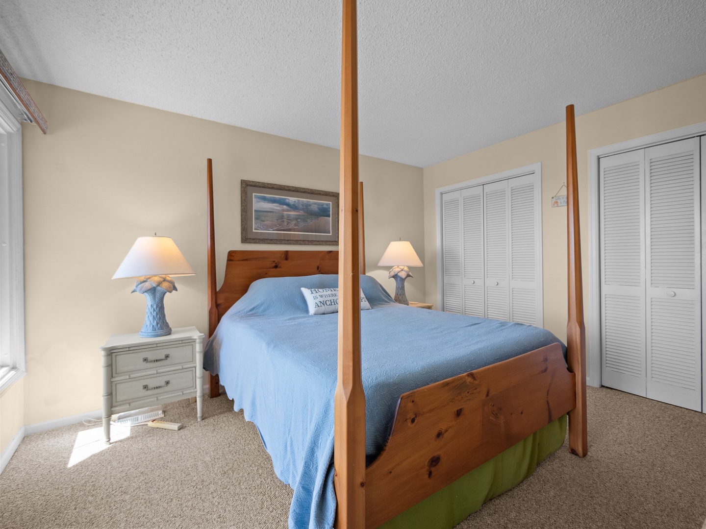 Drift off peacefully in your elegant four-poster bed, surrounded by soft blue linens and warm natural light filtering through the room.