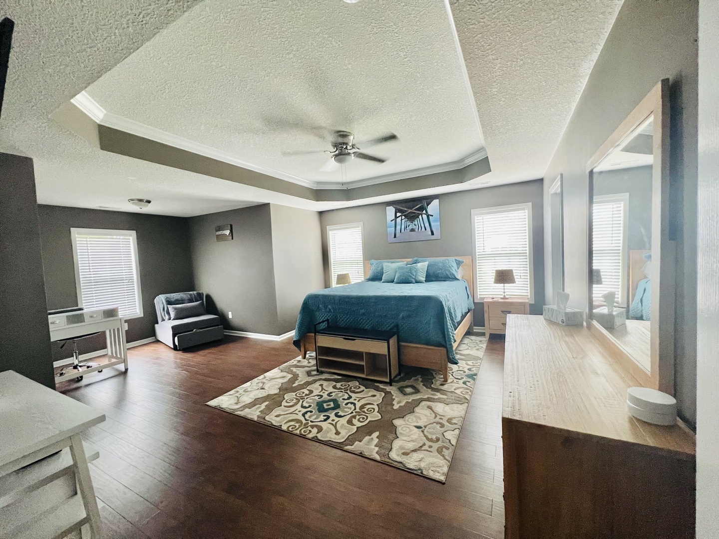 Relax in your spacious master suite with elegant tray ceiling, cozy seating area, and stylish modern furnishings throughout.