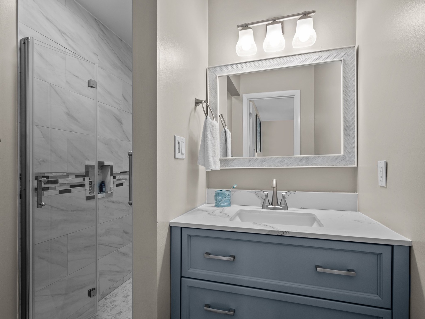 Step into your private bathroom sanctuary with elegant marble-inspired shower, crisp vanity lighting, and thoughtful storage for your comfort.