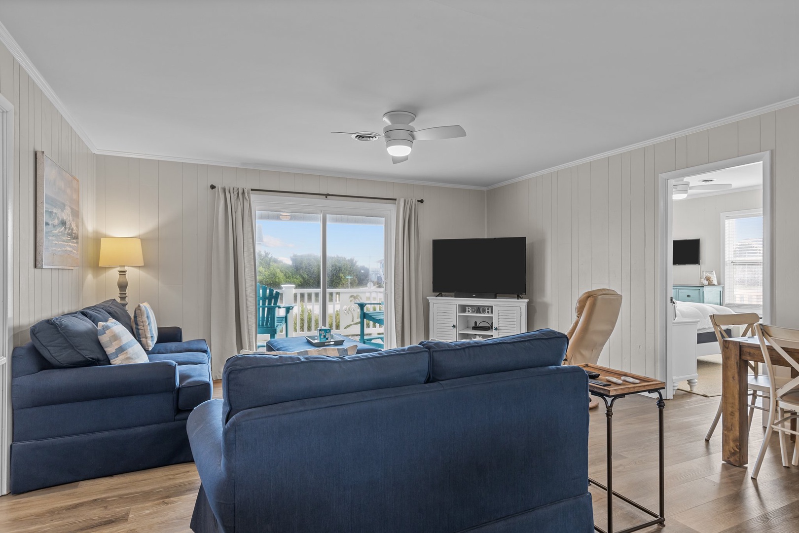 Sink into plush navy sofas and enjoy your morning coffee while natural light streams through windows overlooking the peaceful balcony.