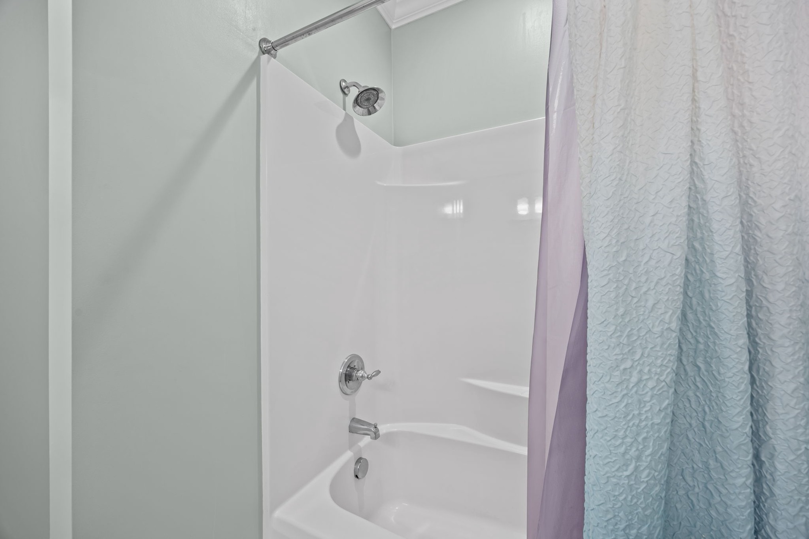 Step into your private bathroom featuring a clean tub-shower combo with modern fixtures and fresh towels waiting for your arrival.