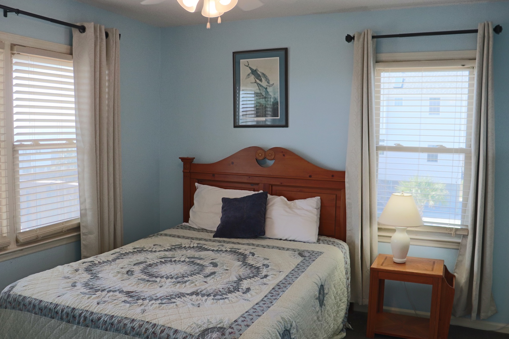 Settle into your cozy bedroom with soft blue walls and natural light streaming through windows.