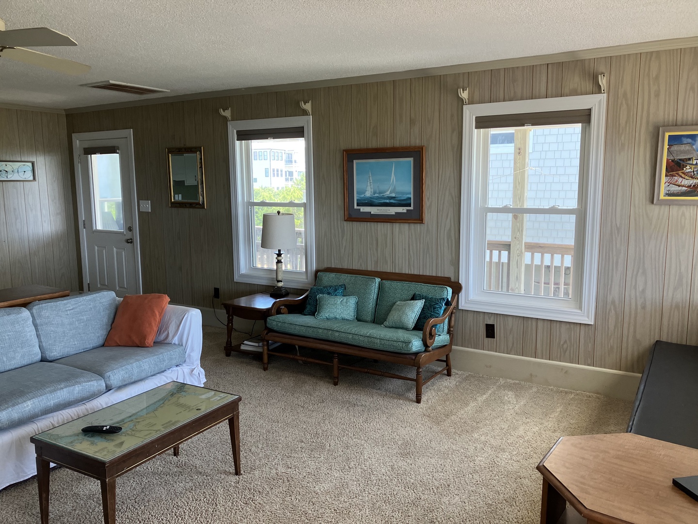 Settle into your spacious living room with nautical charm, featuring comfortable seating and city views through bright windows.