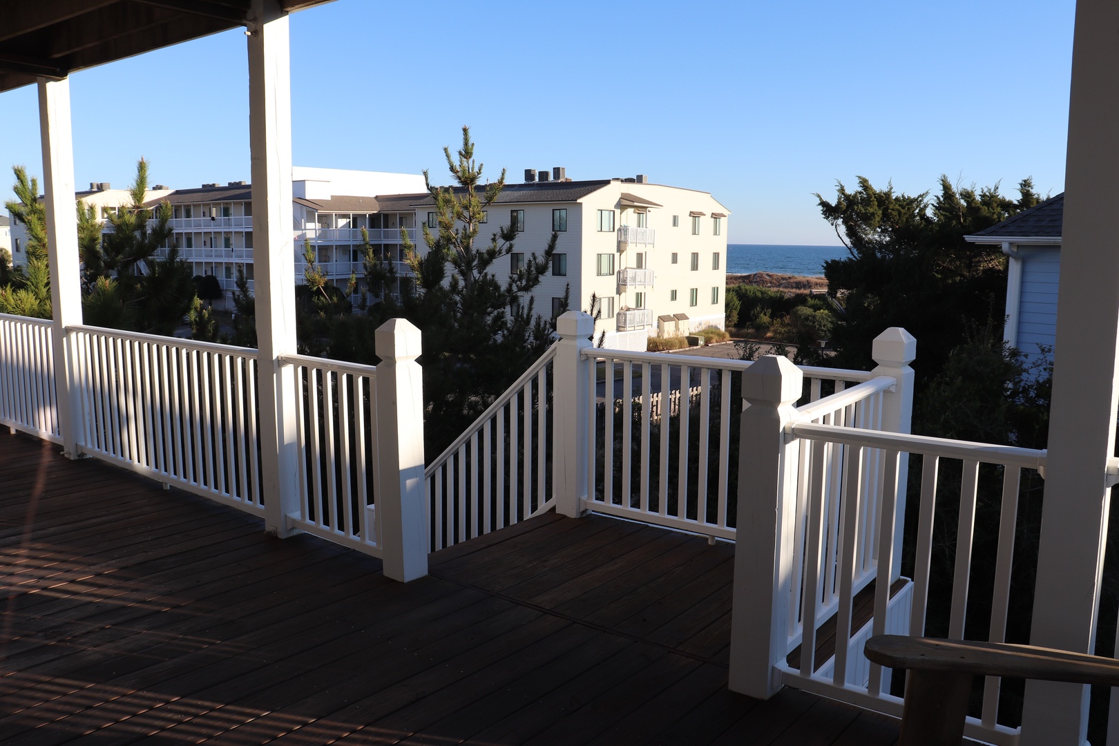 Your private balcony offers glimpses of the sparkling sea through coastal buildings, perfect for morning coffee or evening relaxation.
