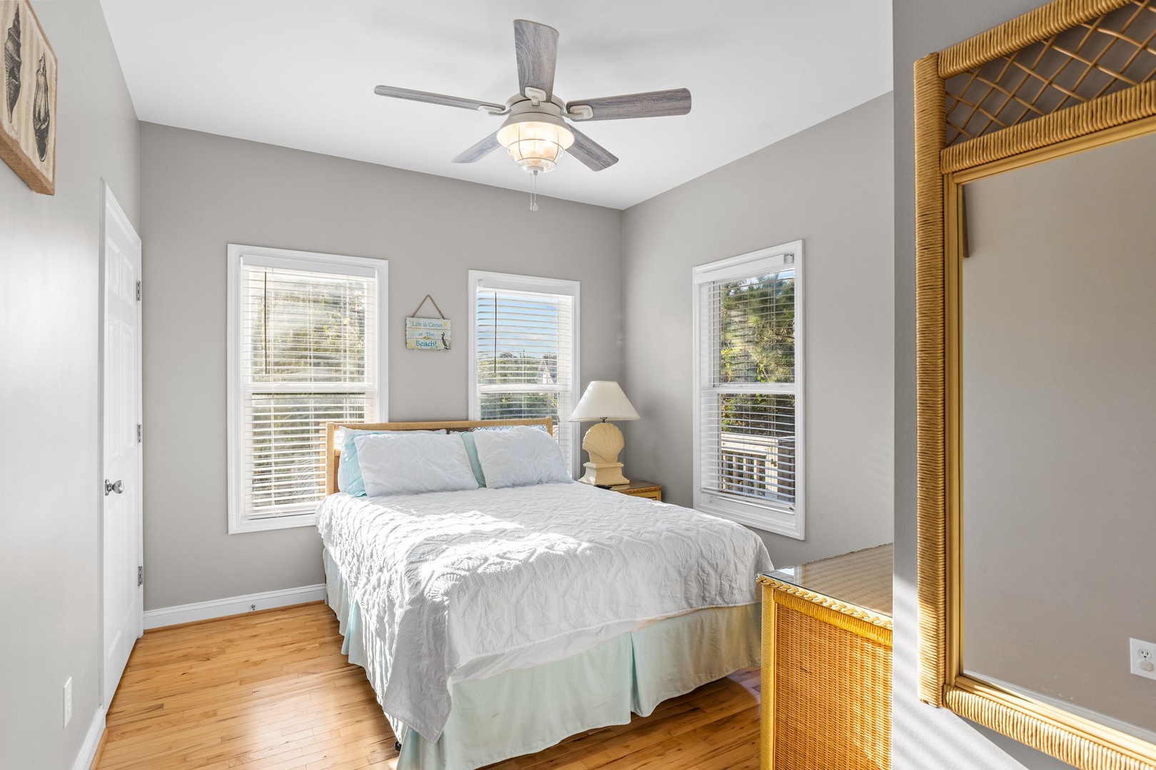 Drift into peaceful sleep in this bright bedroom with coastal charm and hardwood floors beneath your feet.