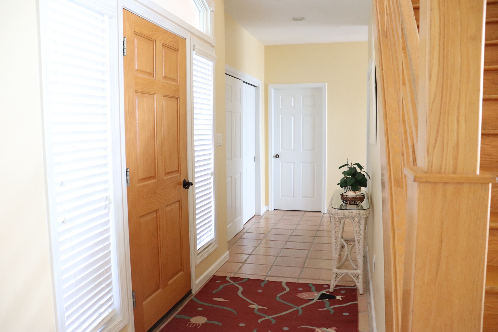 Step into your welcoming entryway with beautiful tile floors and bright natural light streaming through shuttered windows.
