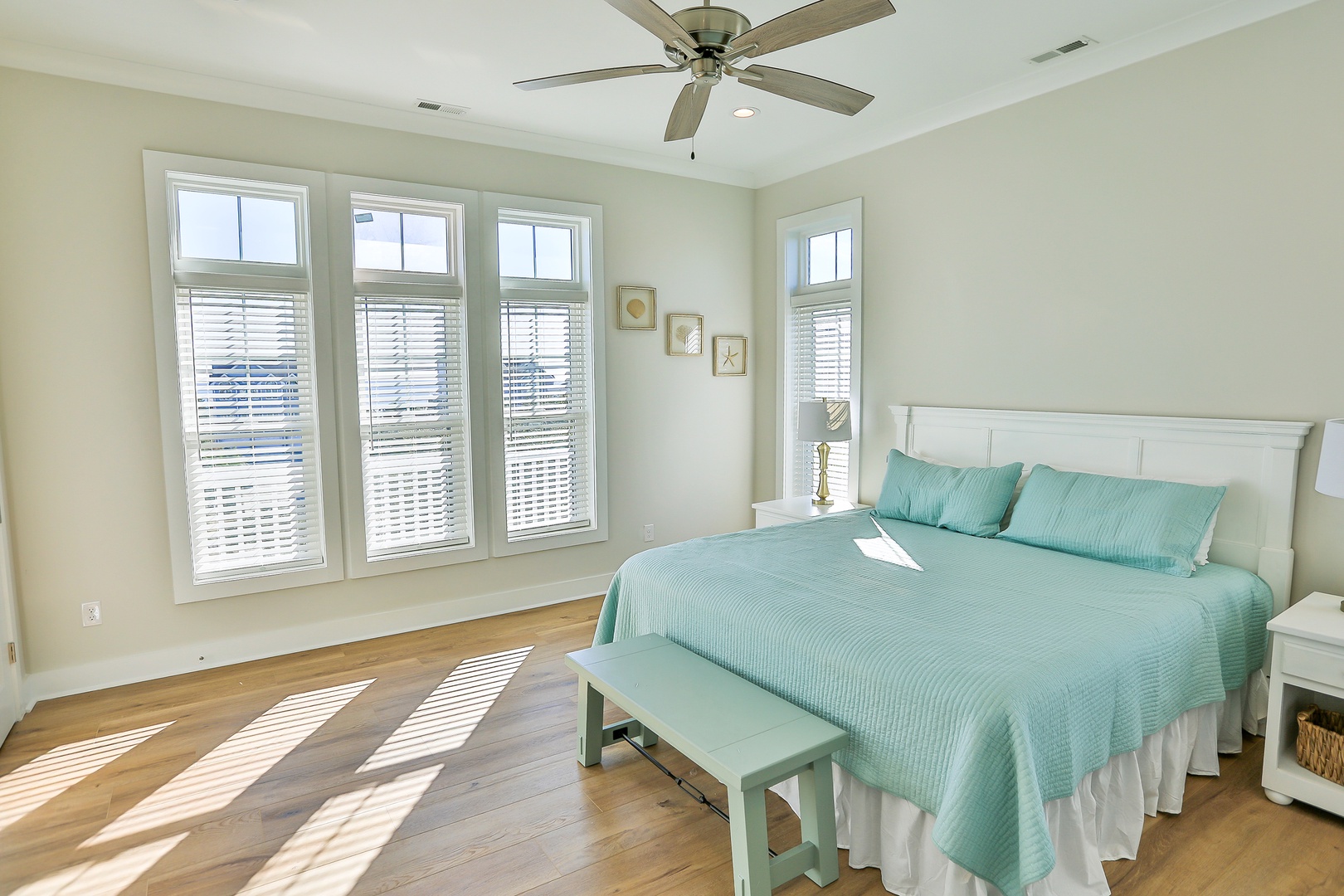 Wake up refreshed in your serene bedroom, where gentle morning light filters through plantation shutters and ocean breezes flow from the overhead fan.