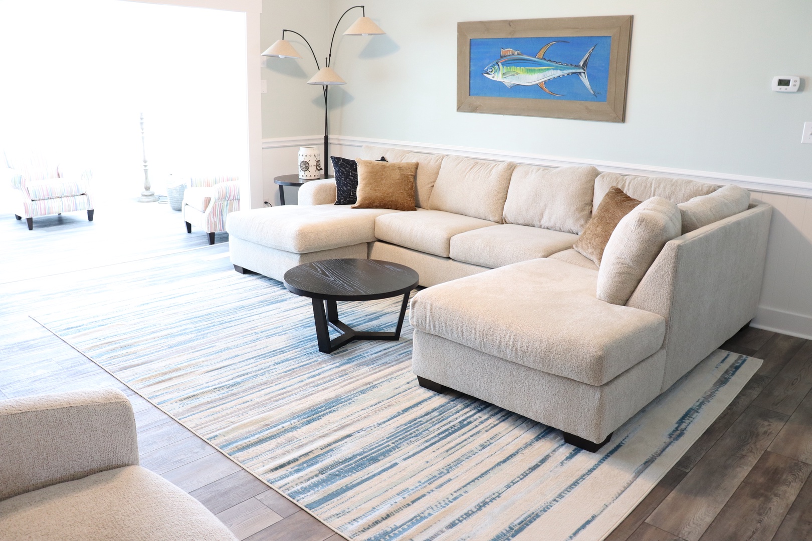 Sink into the plush sectional sofa and unwind in your coastal-inspired living space, complete with nautical artwork and stylish comfort.