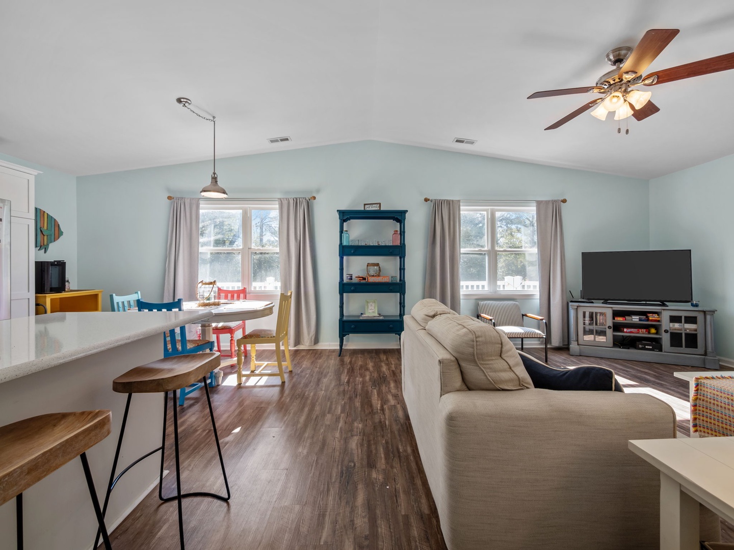 Relax in your bright, open-plan living space with cozy seating, modern kitchen, and cheerful coastal vibes.