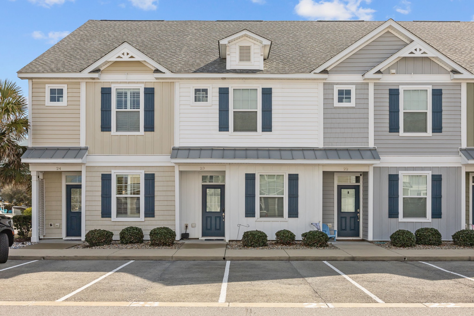Modern coastal townhome complex featuring charming shutters and traditional architecture in a well-maintained community setting.