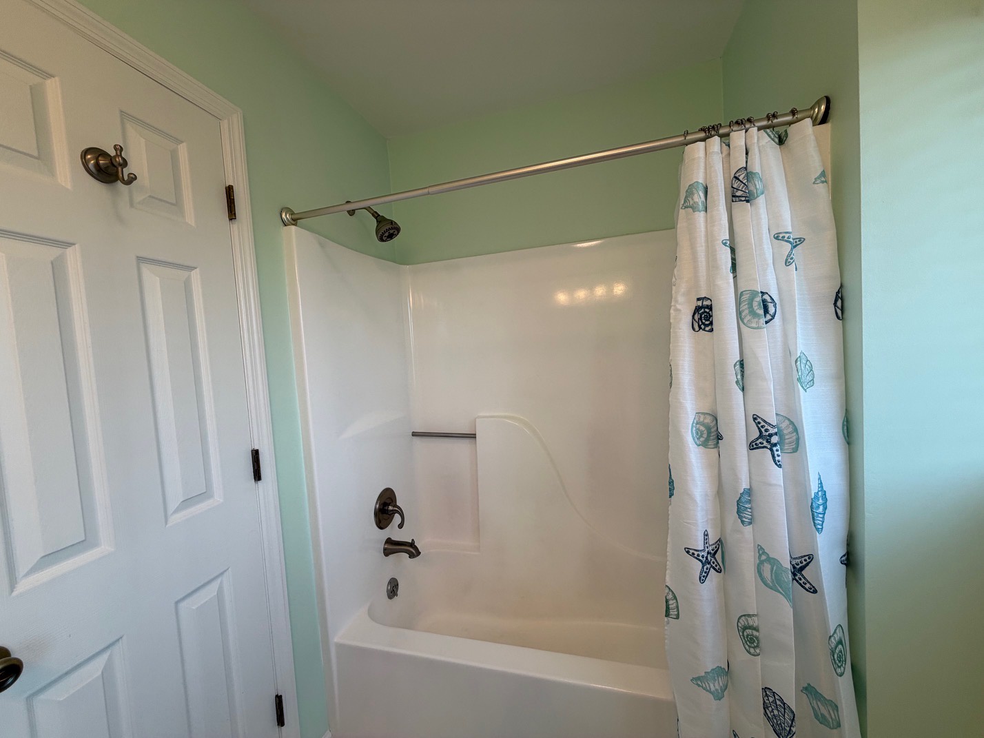Unwind in your private bathroom sanctuary with soothing coastal vibes and a charming seashell curtain.