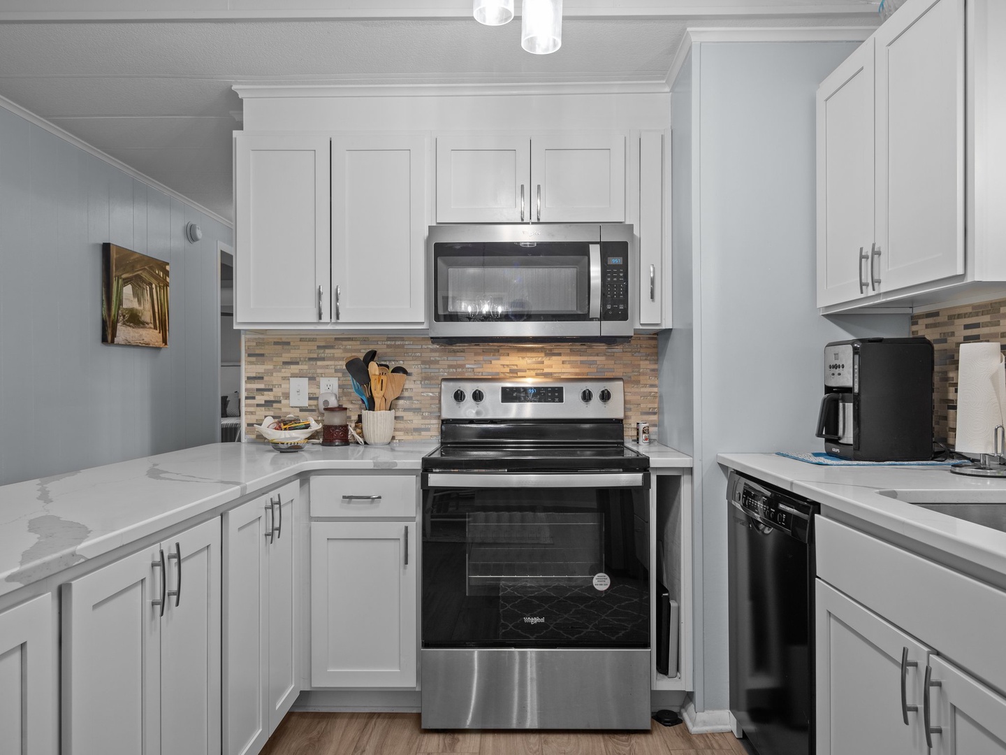 Your beautifully renovated kitchen awaits with gleaming white cabinets, marble countertops, and stainless steel appliances ready for your culinary adventures.