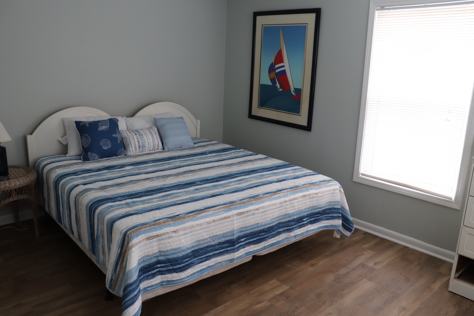 Relax in your coastal-themed bedroom with crisp blue linens and natural light flooding through your window.
