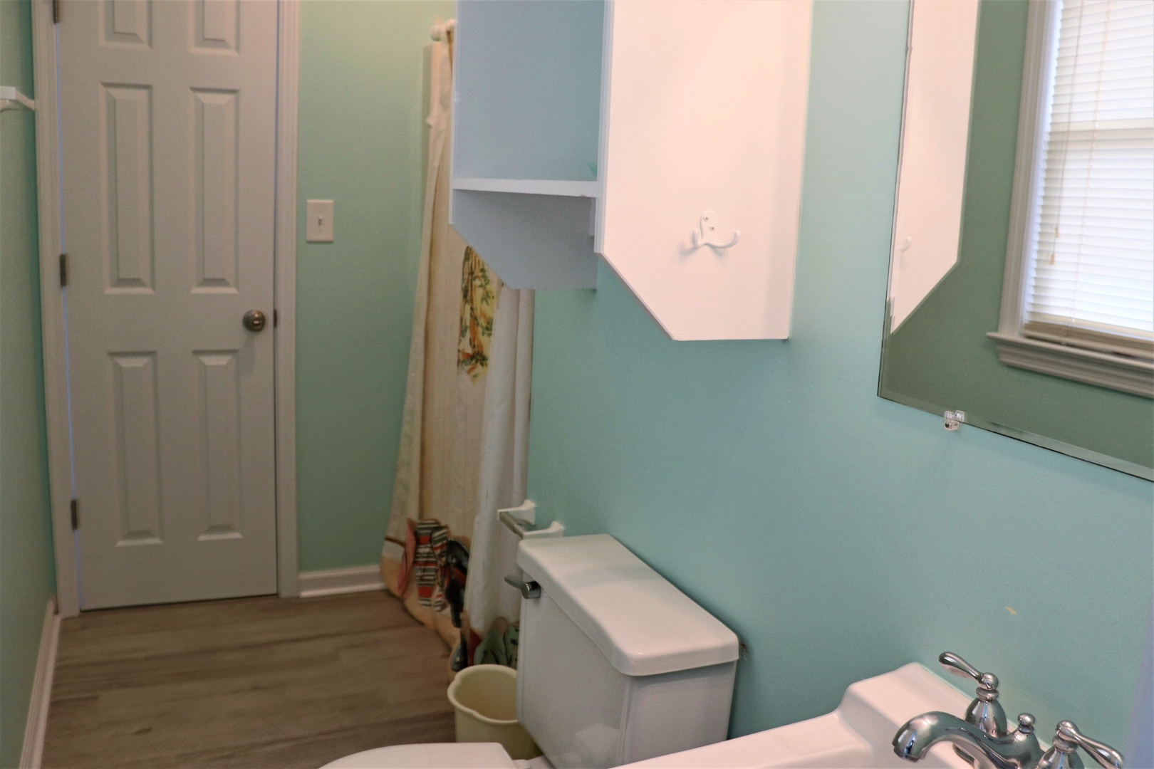 Refresh in your cheerful turquoise bathroom with modern fixtures and plenty of natural light streaming through the window.